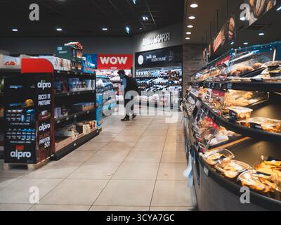 Lombardy, Italy - October 1st 2025 Man Grocery Shopping in an Italian Aldi Discount Supermarket Selecting Items from Shelves in a Brightly Lit Aisle Stock Photo
