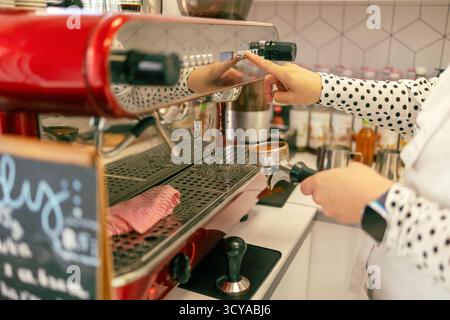 Close-up of female barista preparing coffee in a coffee machine Stock Photo