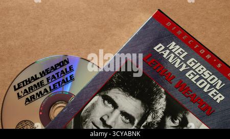 'Lethal Weapon' movie; DVD edition; disc with cover featuring 'Mel Gibson' and 'Danny Glover', isolated on light blank background, top angle shot Stock Photo