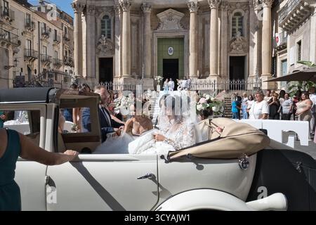 Traditional and religious italian wedding in Catania Sicily: the bride, accompanied by her mother, is arriving on the car in front of the church Stock Photo