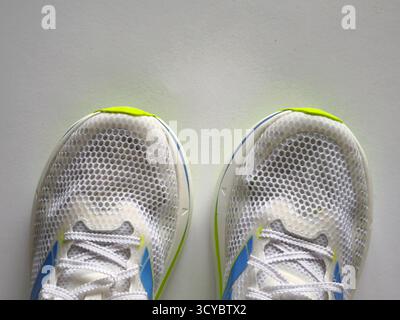 A pair of running shoes in predominantly white on a white background Stock Photo