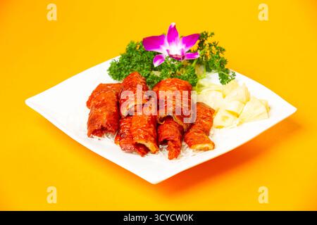 Crispy Fried Intestines Roll with rice and vegetable served in plate isolated on orange background side view of hong kong food Stock Photo
