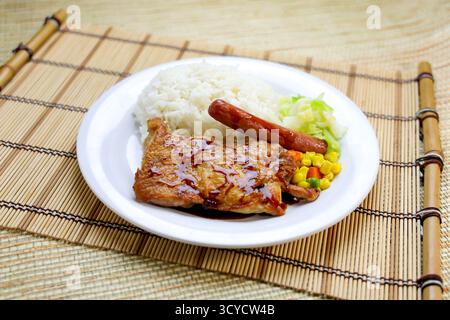 Japanese style sauteed chicken with, sausage, rice and vegetables served in plate isolated on table side view of Hong Kong food Stock Photo