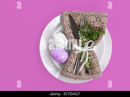Happy Easter. Easter celebration concept. Top view vertical Napkin empty white and yellow plate, Easter eggs, on isolated pink background. Copy space, Stock Photo