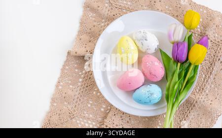 Happy Easter. Easter celebration concept. Top view vertical empty white and yellow plate, Easter eggs, on isolated white background. Copy space, place Stock Photo