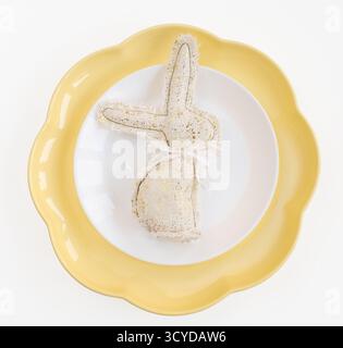 Happy Easter. Easter celebration concept. Top view vertical empty white, yellow plate, decorative rabbit, eggs, isolated white background. Copy space, Stock Photo