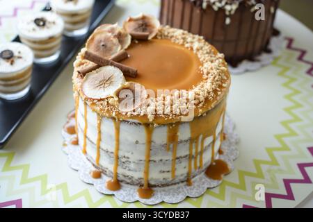 Assorted Cakes and Desserts on Display include caramel cake with fig slices, a chocolate cake with sprinkles, and layered dessert cups closeup side vi Stock Photo