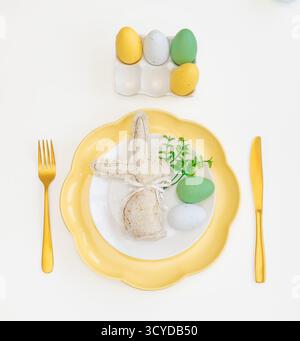 Happy Easter. Easter celebration concept. Top view vertical empty white, yellow plate, decorative rabbit, eggs, isolated white background. Copy space, Stock Photo