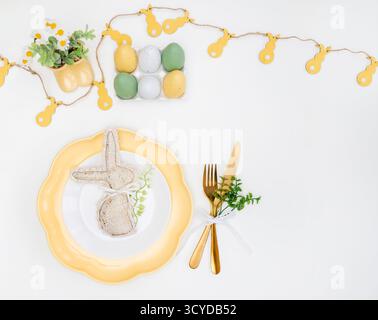 Happy Easter. Easter celebration concept. Top view vertical empty white, yellow plate, decorative rabbit, eggs, isolated white background. Copy space, Stock Photo