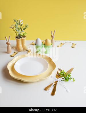 Happy Easter. Easter celebration concept. Top view vertical empty white and yellow plate, Easter eggs, on isolated white background. Copy space, place Stock Photo