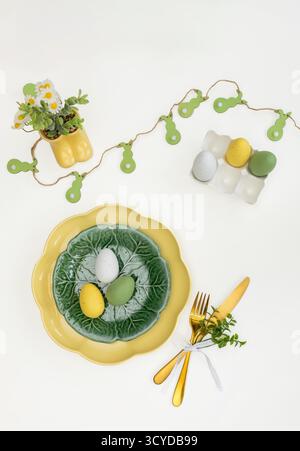 Happy Easter. Easter celebration concept. Top view vertical empty green and yellow plate, Easter eggs, on isolated white background. Copy space, place Stock Photo