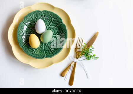Happy Easter. Easter celebration concept. Top view vertical empty green and yellow plate, Easter eggs, on isolated white background. Copy space, place Stock Photo