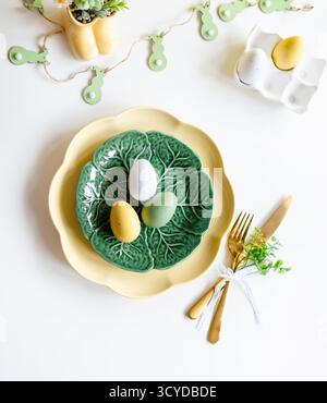 Happy Easter. Easter celebration concept. Top view vertical empty green and yellow plate, Easter eggs, on isolated white background. Copy space, place Stock Photo