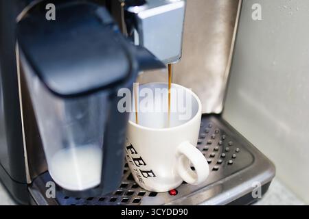 Coffee Machine Dispensing Fresh Espresso into White Ceramic Mug on Drip Tray in Cozy Home Environment Stock Photo