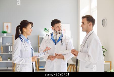 Team of doctors standing in clinic, sharing ideas and collaborating on patient treatment plans. Stock Photo