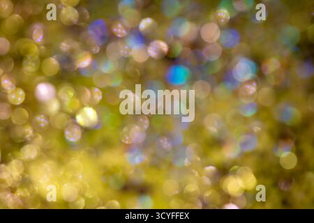 Bright yellow bokeh on dark background – festive glitter lights and blurred New Year background Stock Photo