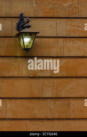 Vintage Wall Lantern Mounted on Rustic Orange Brick Wall for Exterior Lighting and Decor Stock Photo