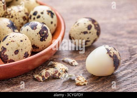 Closeup view of quail eggs in wooden plate on table Stock Photo