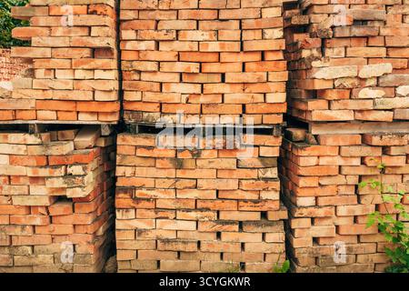 Stack of old weathered bricks used for construction or recycling. Selective focus. Stock Photo