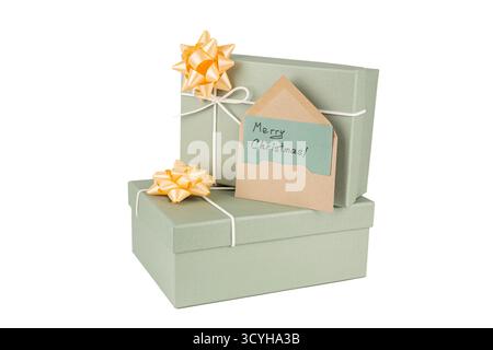 Christmas green gift boxes with yellow ribbons and envelope with handwritten Merry Christmas words on white background. Three Christmas gift boxes sta Stock Photo