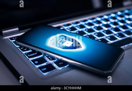 Cyber fraud. Protect phone with cybersecurity. AI data privacy from identity theft and hacker. Smartphone and laptop computer ransomware or antivirus. Stock Photo