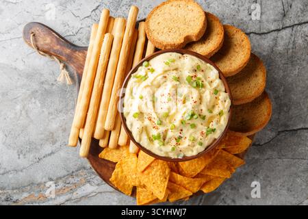 Deviled Egg Dip festive buffet appetizer with chips, breadsticks and biscuit close-up in a plate on the table. Horizontal top view from above Stock Photo
