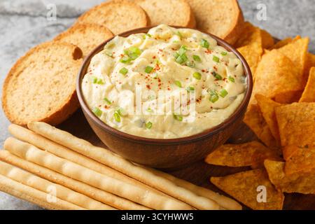 Deviled Egg Dip festive buffet appetizer with chips, breadsticks and biscuit close-up in a plate on the table. Horizontal Stock Photo