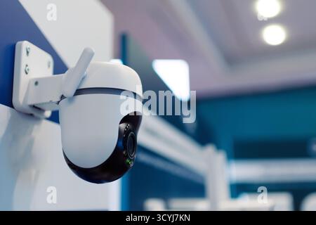 High-tech standalone CCTV surveillance camera displayed at a technology trade show. Isolated close-up of smart home security device with LED indicator Stock Photo