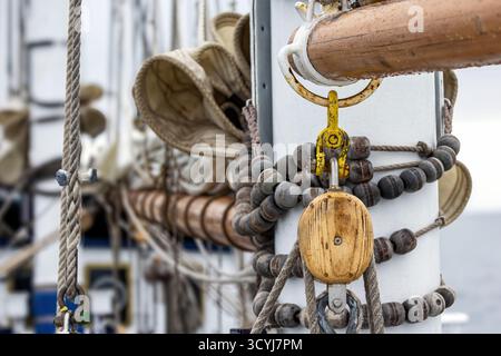 Detail of the pulleys, sails and rigging of a sailing ship. Vintage style abstract background with selective focus. Stock Photo