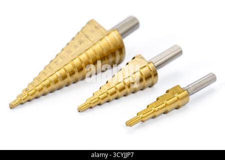 Three titanium-coated step drill bits of different sizes arranged on a white background, showcasing precision metal tools for drilling holes in metal Stock Photo