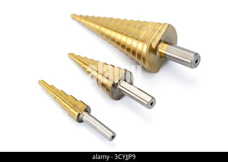 Three titanium-coated step drill bits of different sizes arranged on a white background, showcasing precision metal tools for drilling holes in metal Stock Photo