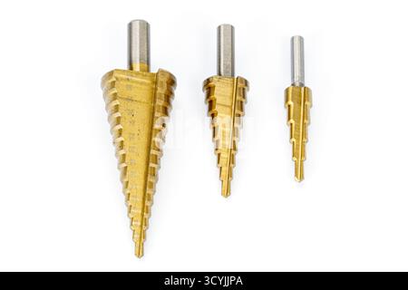 Three titanium-coated step drill bits of different sizes arranged on a white background, showcasing precision metal tools for drilling holes in metal Stock Photo