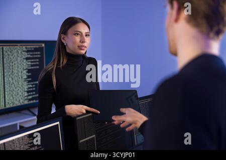 Two cybersecurity professionals collaborating in a security operations center Stock Photo