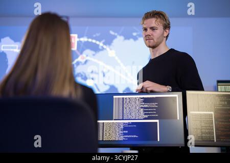Team analyzing cyber threats using monitors in a security operations center Stock Photo