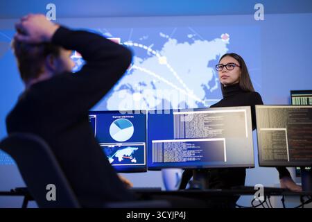 Cybersecurity analysts monitoring threats in a security operations center environment Stock Photo