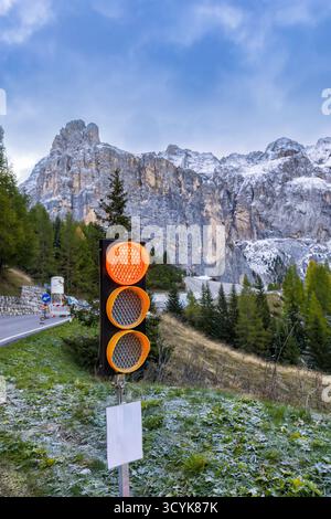 A red stop traffic light on a forest road in the mountains. Vertical photo. Stock Photo