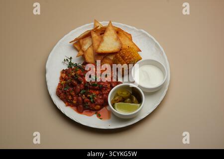 A Delicious Vegetarian Dish Accompanied by Fried Snacks, Flavorful Dips, and Garnishes Stock Photo