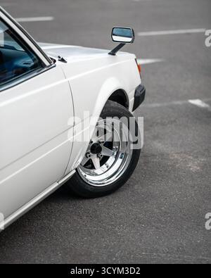 White old japanese 1980s car with fender mirrors. Side part of the JDM car - view from the back. Stock Photo