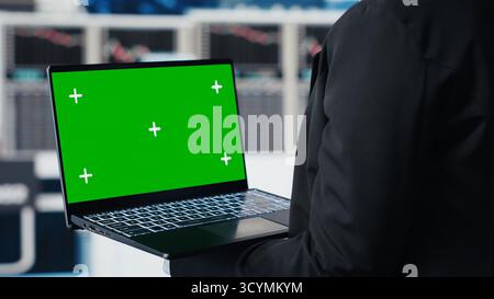Business professional using isolated screen laptop to review performance dashboards metrics. Management executive evaluating annual report data KPIs using chroma key notebook Stock Photo