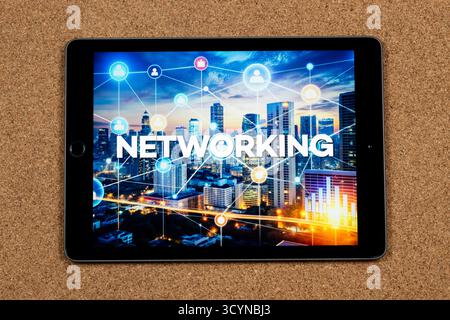 Close up to a tablet with the networking word over a technology concept and a cork background Stock Photo