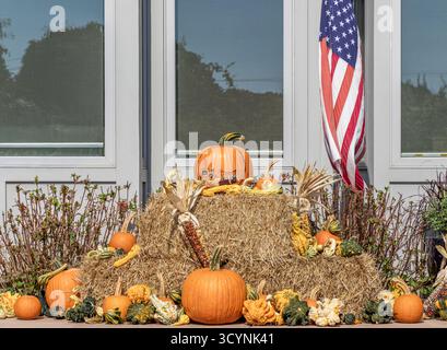 pumpking and gourds displayed around and on bales of hay Stock Photo