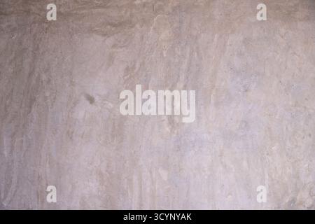 Distressed gray concrete wall texture with exposed aggregate and mottled finish. Grunge surface for background or creative architectural design. Stock Photo