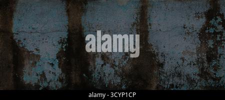 Dark grungy and highly textured photograph of distressed concrete. Surface shows severe aging, with peeling remnants of muted blue or teal paint layer Stock Photo