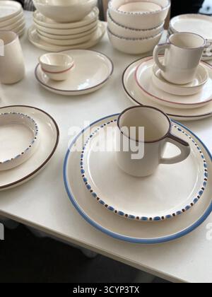 Ceramic tableware with minimalist design on display, featuring plates, bowls, and mugs. Mobile photo Stock Photo