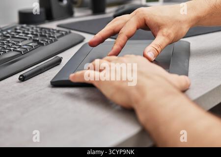 male hands drawing and retouching image on pc computer, using graphic digital tablet and stylus pen, finger touching on screen Stock Photo