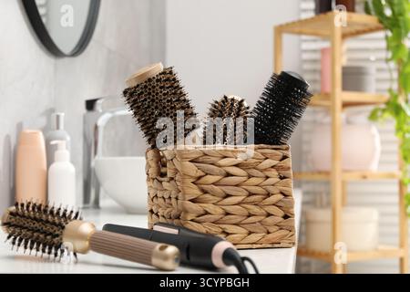 Different hair styling tools on white table in bathroom, closeup Stock Photo