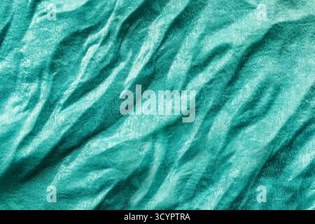 Wrinkled silk turquoise color fabric closeup as a background Stock Photo