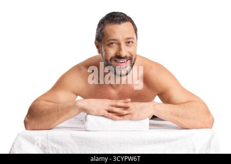 Man laying on a massage bed and smiling isolated on white background Stock Photo