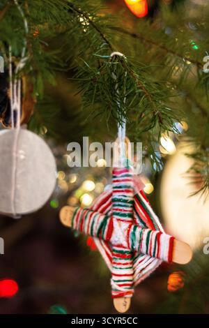 Striped Yarn and Stick Ornament Hanging on a Christmas Tree Stock Photo