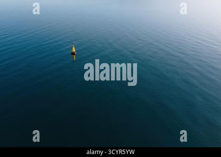 Navigational buoy floating on calm blue sea water in reykjavik Stock Photo